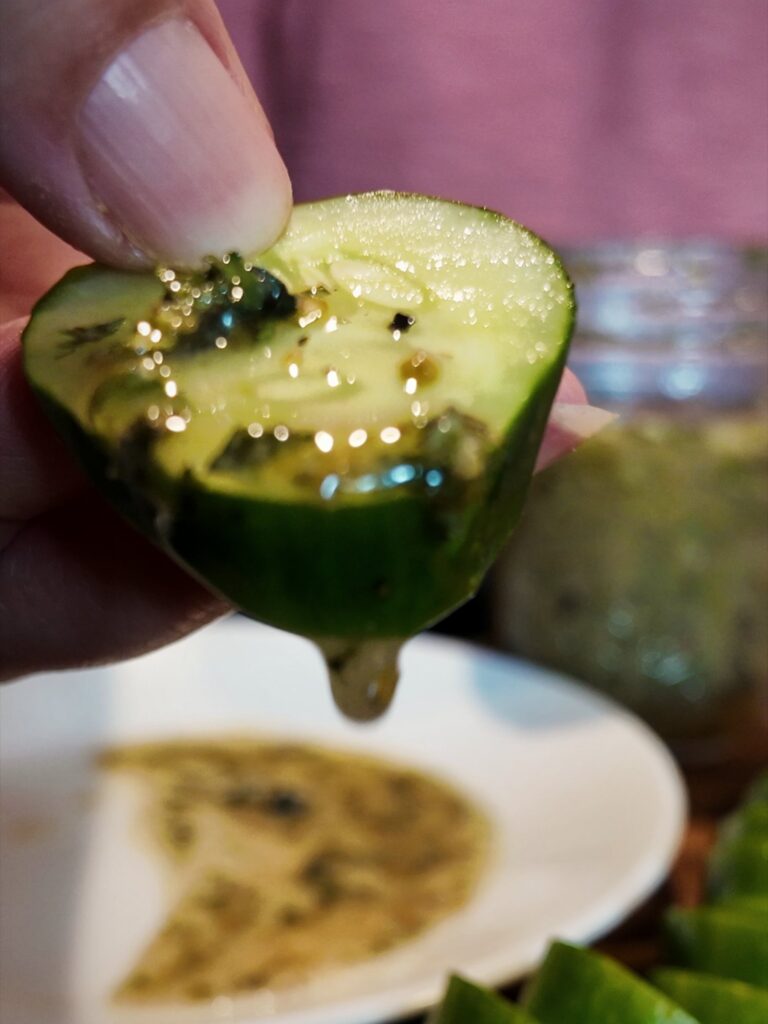 Cucumber slice dipped in homemade Italian dressing over a plate