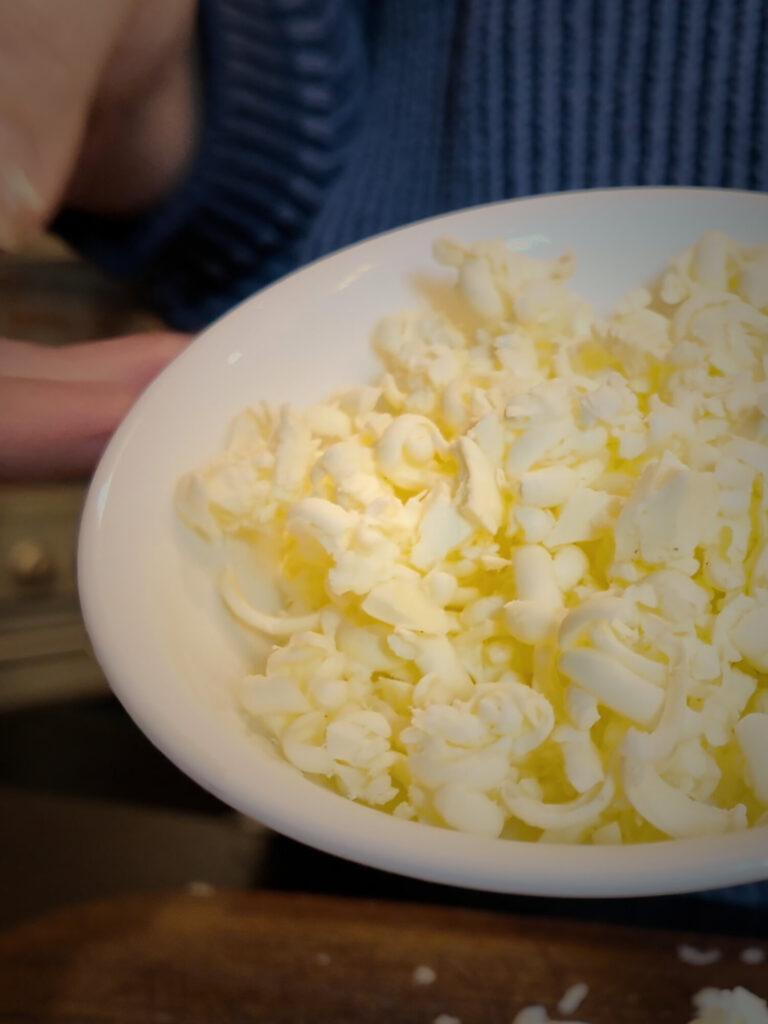 White bowl full of separate shreds of hand-grated frozen butter