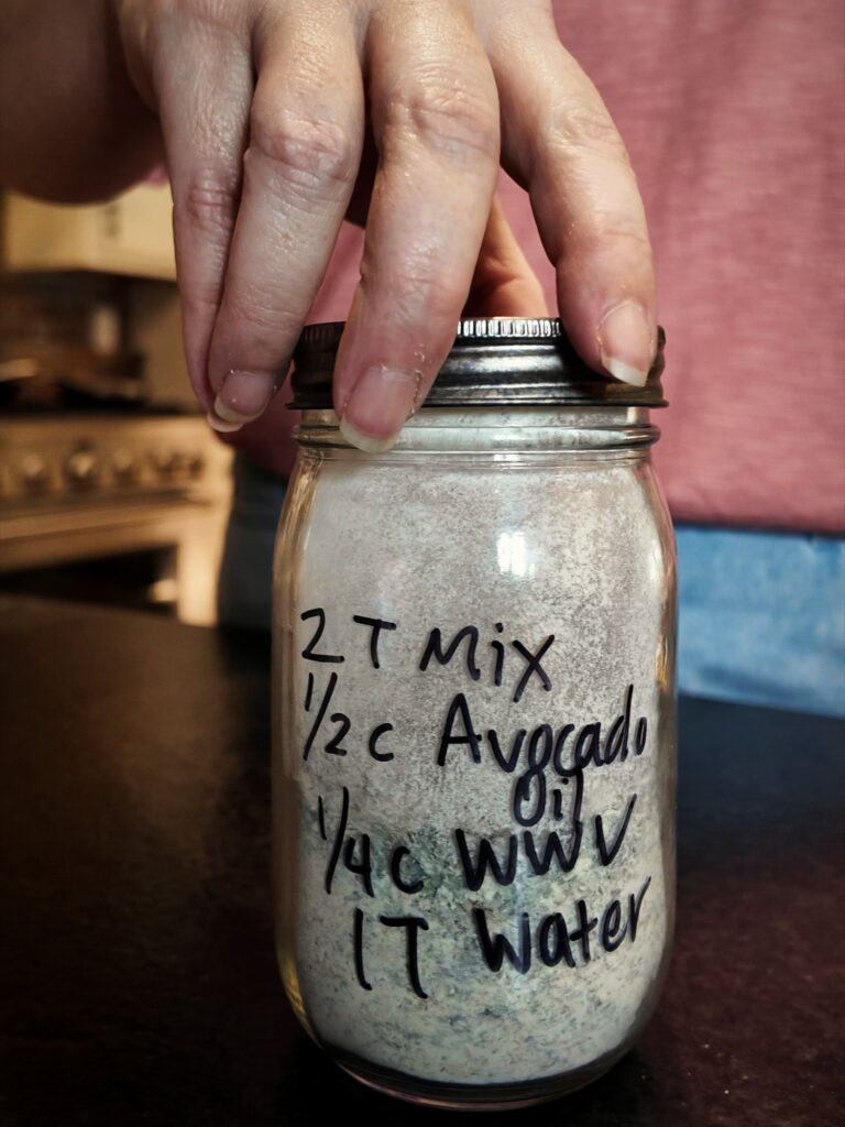 Jar of Italian dressing mix labeled 2T mix, 1/2 c avocado oil, 1/4 c WWV, 1T water