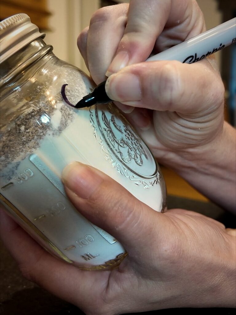 Writing on a mason jar of dry cream of soup mix with a black marker
