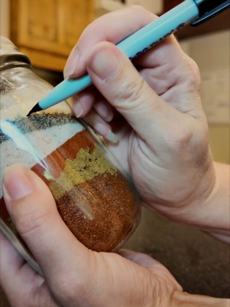 Writing a label on a jar of taco seasoning spices