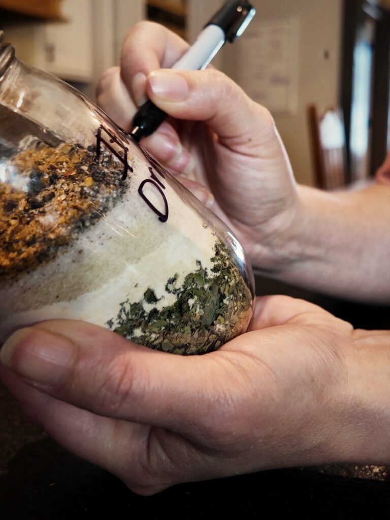 Labeling a jar of layered Italian dressing mix with a marker