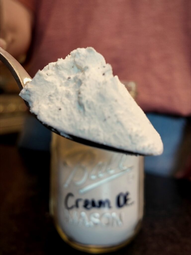 Spoonful of dry cream of soup mix held over a labeled mason jar