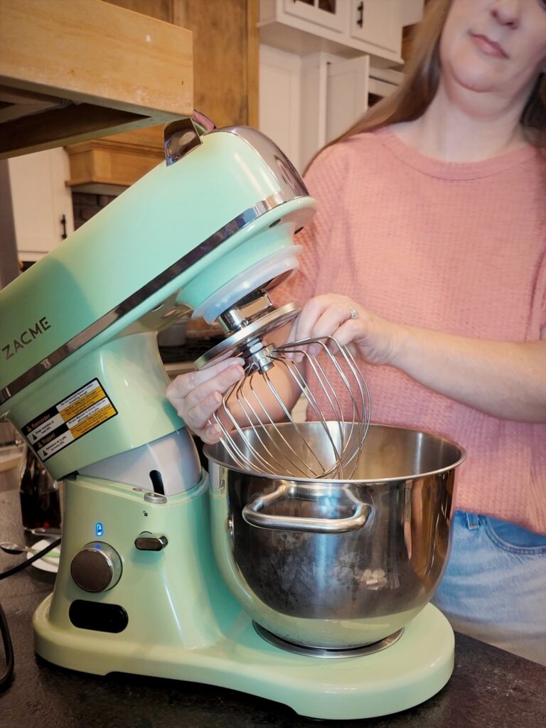 Mint-green ZACME stand mixer with the whisk attachment and a stainless steel bowl